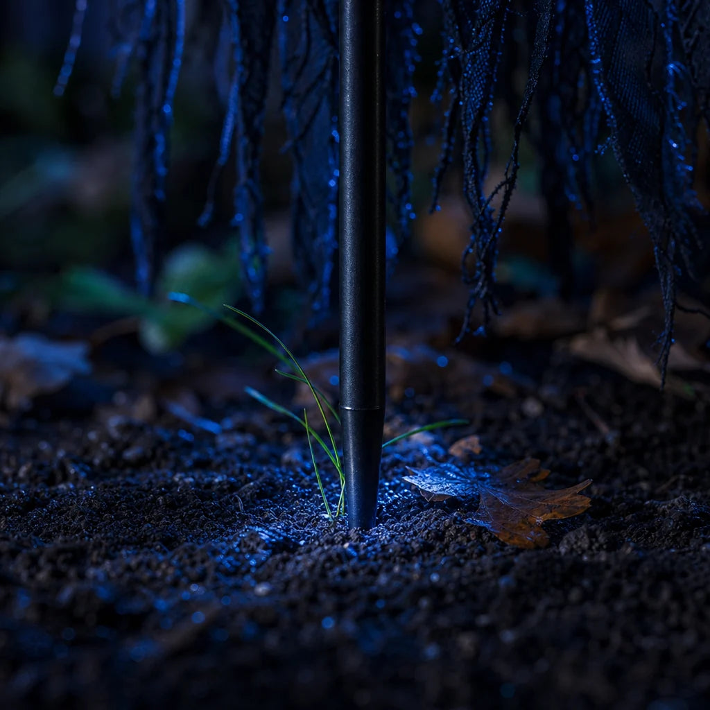 Ground level: the thin metal spike pushed straight into dark garden soil