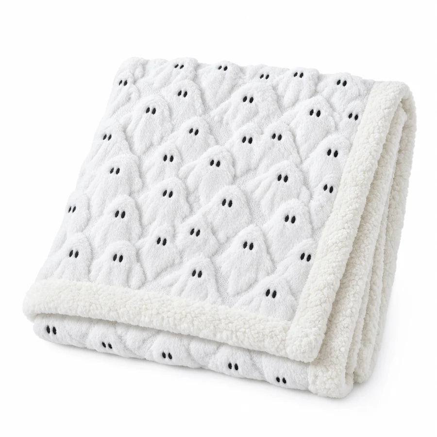 The ghost-print throw folded in half on white, raised ghost texture and embroidered eyes