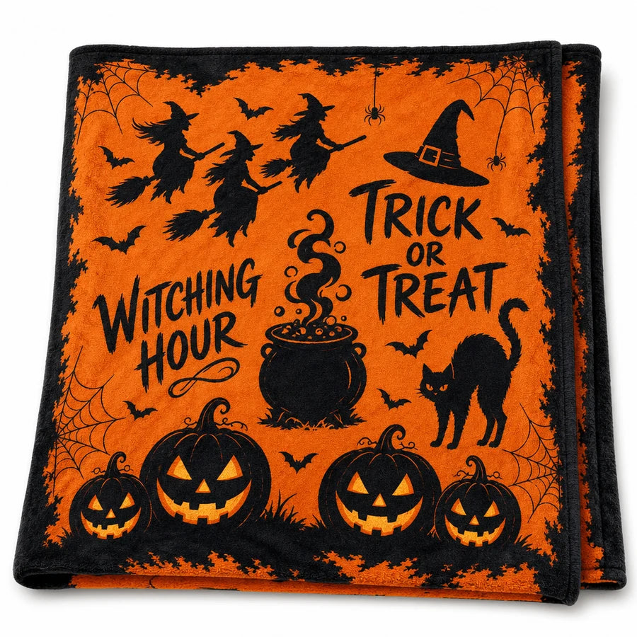 The witch-print throw folded in half on white, showing witches, a cauldron and jack-o'-lanterns