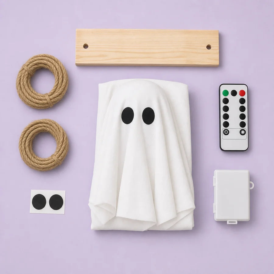 Overhead flat-lay on pale lilac: the folded cloth with its eyes, the pine board, two coils of cord and the remote
