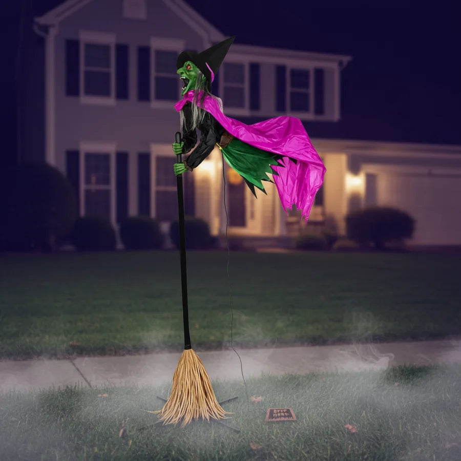 Thornfield 10.5 ft Witch Animatronic set up on a suburban front lawn at night, lit against the house