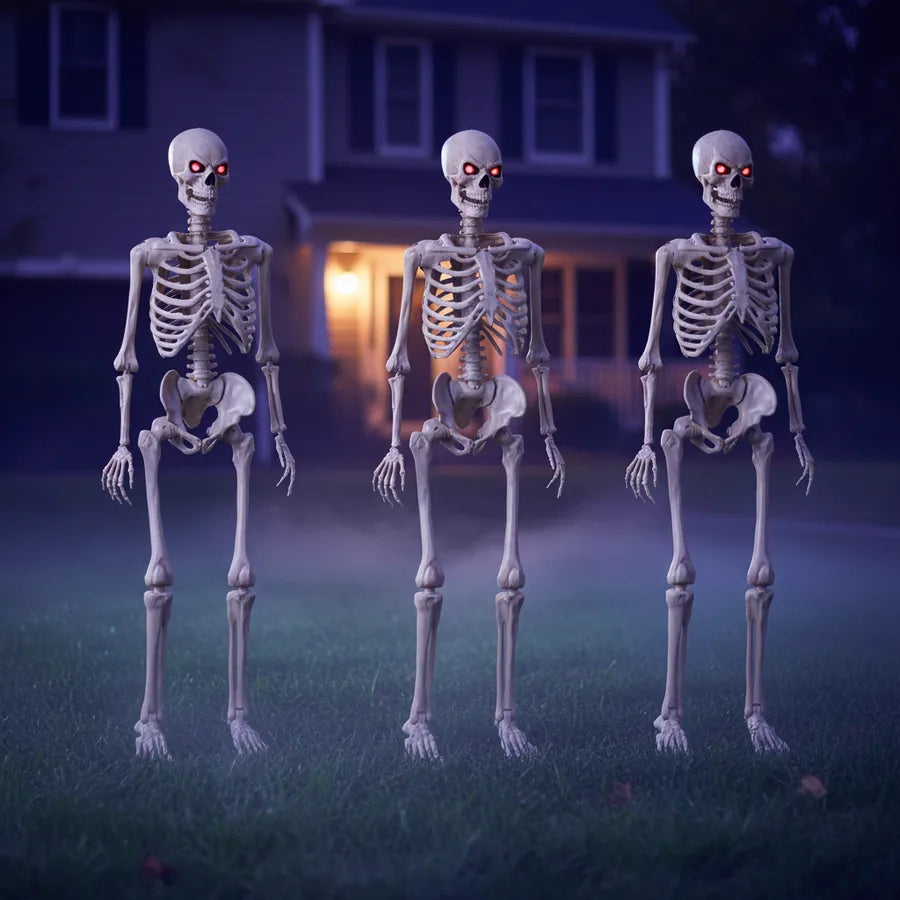 Fenwick 5 ft Poseable Skeleton, 3 pack set up on a suburban front lawn at night, lit against the house