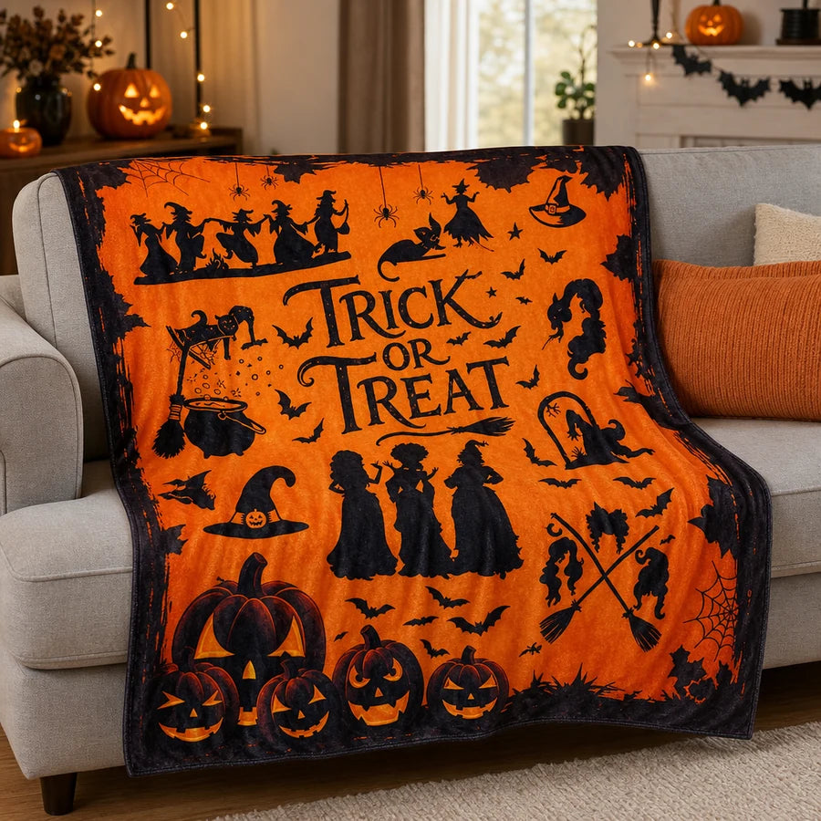Draped over a grey sofa in a softly lit living room with small pumpkins nearby