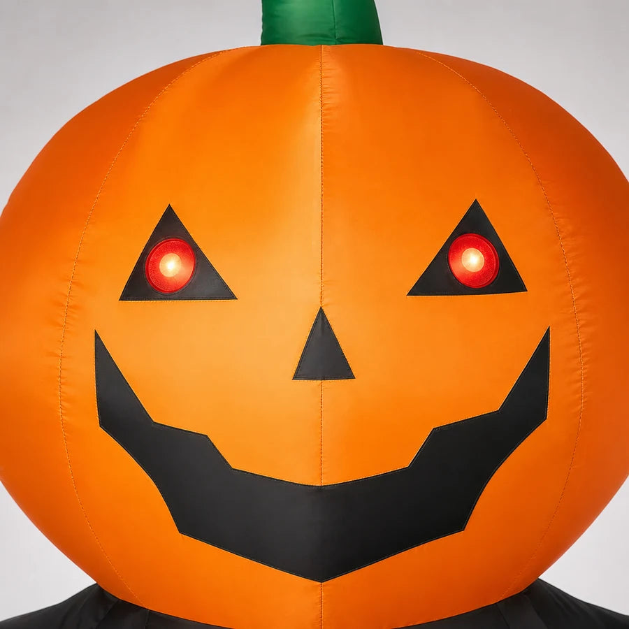 Macro of the grinning jack-o'-lantern face, red eyes lit and a green stem on top