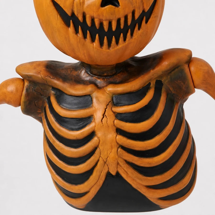 Close crop of the black-ribbed torso where the pumpkin skull meets the collarbone