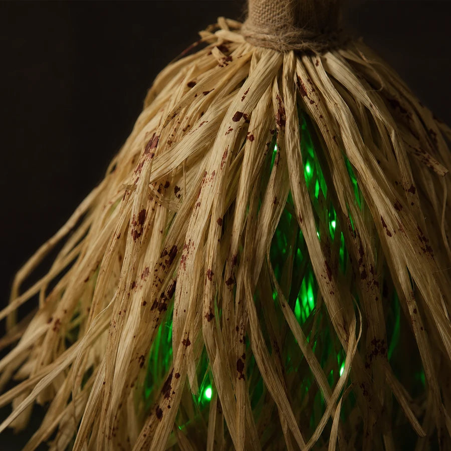 Close on the straw: coarse pale fibres, dark mottling through them, bulbs glowing inside