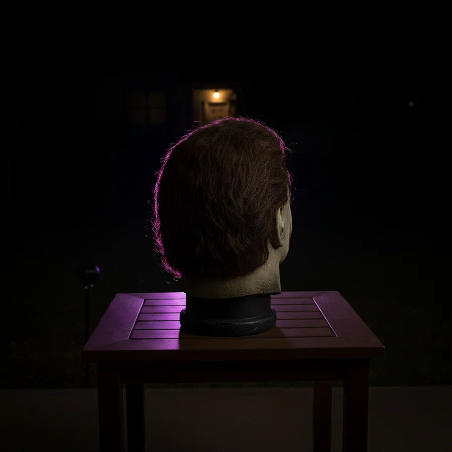 Coffinwood Figure on a porch at night